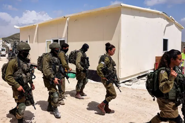 Soldados israelíes patrullan fuera de la construcción de un edificio portátil en el sitio de Homesh en Cisjordania el 29 de mayo de 2023.