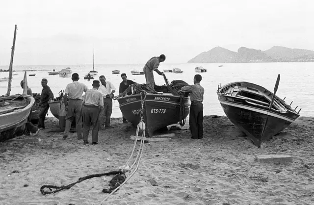 Pescadores en sus pequeñas barcas.