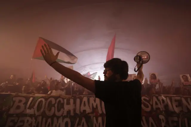 Un manifestante con los brazos en alto y un parlante en la mano derecha de espaldas durante una protesta en Roma, Italia, el 22 de septiembre de 2025