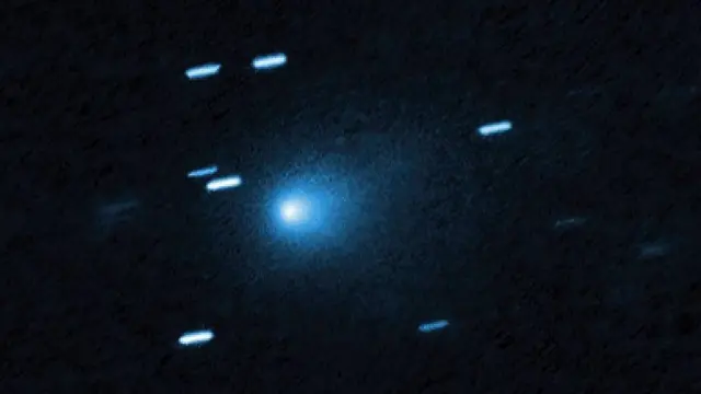 Imagen del cometa interestelar 3I/ATLAS en la que se ve un núcleo brillante con una estela en el fondo azul oscuro