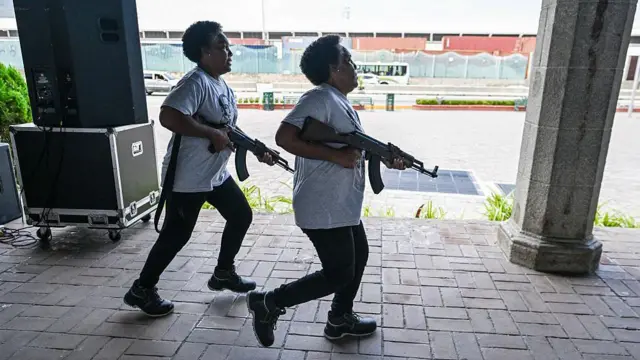 Las hermanas gemelas Carmen y María Santana, miembros de la Milicia Nacional Bolivariana, corren con fusiles en mano durante un ejercicio de entrenamiento militar en La Guaira, Venezuela, el 8 de octubre de 2025.