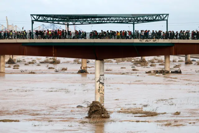 Personas cruzan los puentes que unen a la ciudad de valencia con las comunidades afectadas por la dana