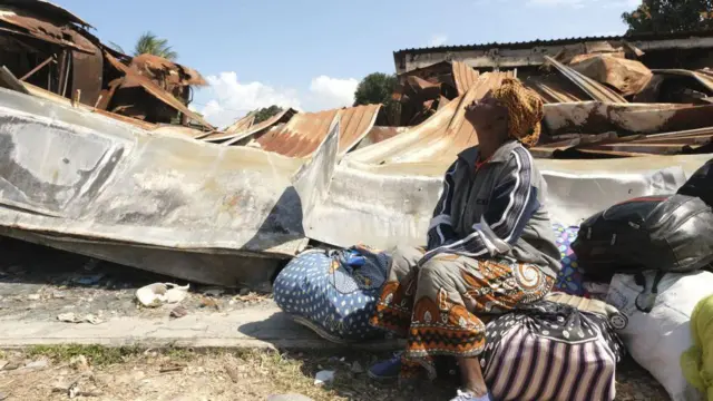 A women sits near the remains of a destroyed bank in Palma, Cabo Delgado province, Mozambique, on 30 September, 2022.