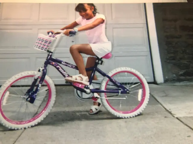 Delimar Vera montando una bicicleta cuando era una niña.