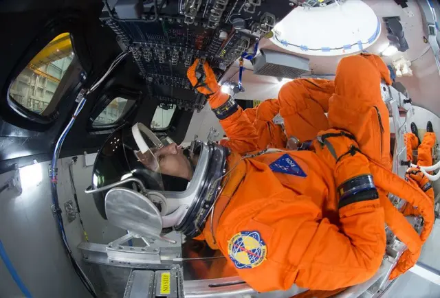 Los ingenieros de trajes espaciales demuestran cómo se organizarían cuatro miembros de la tripulación para el lanzamiento dentro de la nave espacial Orión.