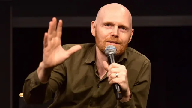 Bill Burr con un micrófono en la mano.