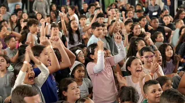 Los estudiantes celebran el anuncio del premio en la cancha de deportes de la escuela.