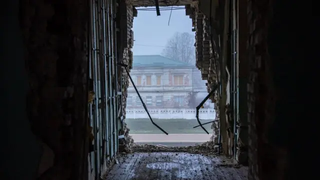 Un edificio visto por el hueco aparentmente causado en un muro por una explosión. 