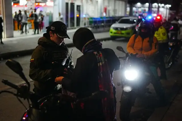 Agentes de policía controlan a un ciudadano en un puesto de control en Ciudad Bolívar, uno de los barrios marginales con mayores tasas de violencia urbana en Bogotá, Colombia, el 16 de octubre de 2024.