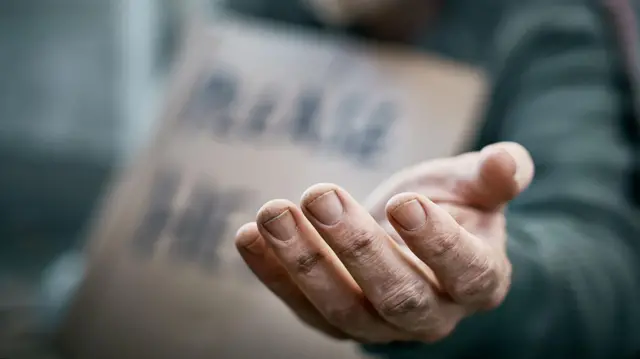 Un mano pidiendo una limosna