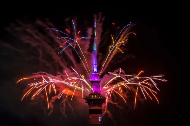 Un espectáculo de fuegos artificiales desde lo alto de la Sky Tower de Auckland da la bienvenida al Año Nuevo.