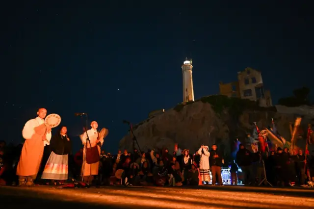 Personas cantan y tocan música en Alcatraz.