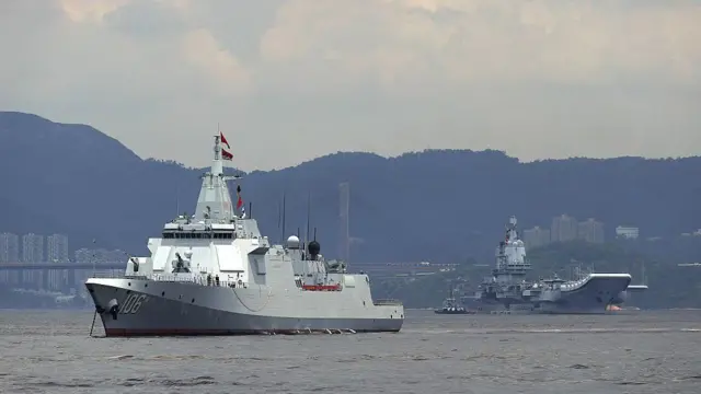 El segundo portaaviones de China, el Shandong, y el destructor de escolta Yanan están anclados después de llegar a Hong Kong, junto con un pequeño remolcador.