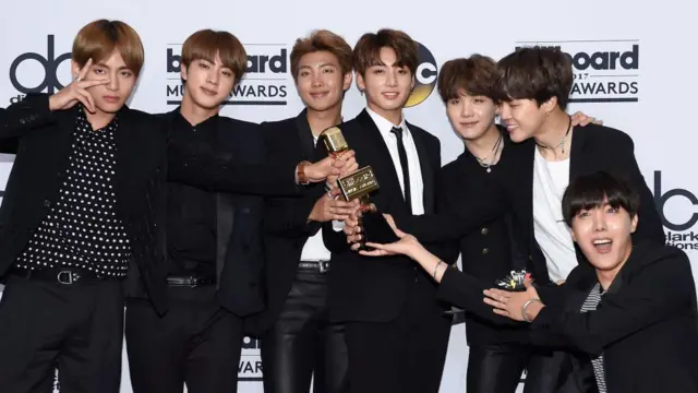 La banda BTS posa con un premio.