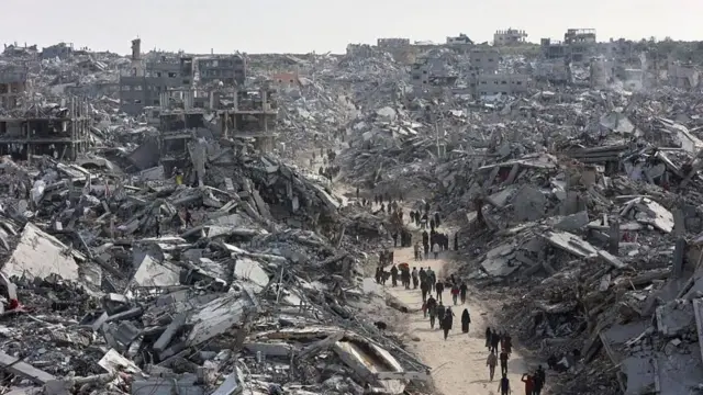 Civiles caminando entre edificios derrumbados en Gaza