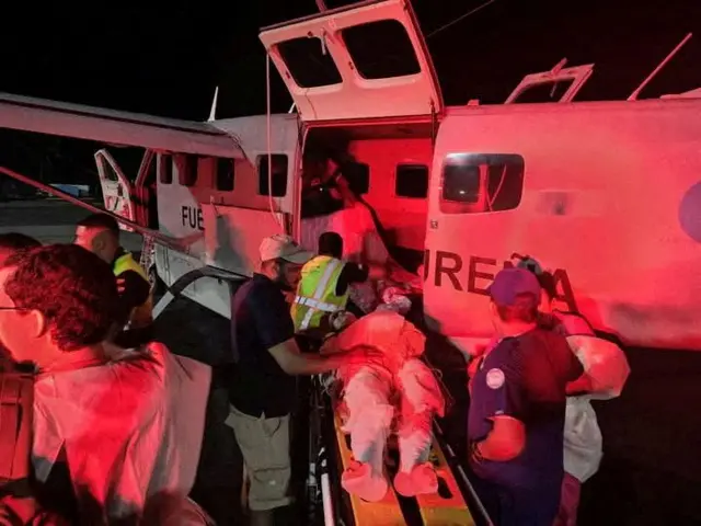 Cuerpos de socorro suben a un herido en una avioneta.