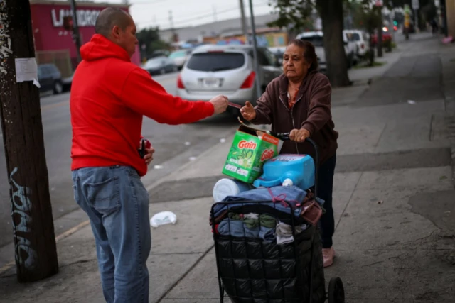 Ron Gochez, voluntario del grupo de defensa de los derechos de los inmigrantes Unión del Barrio, entrega una tarjeta roja de 