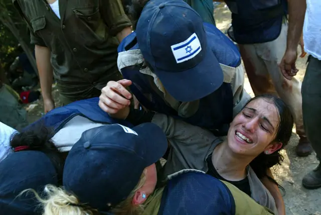 Soldados israelíes se llevan a una colona judía durante la evacuación el 23 de agosto de 2005 en el asentamiento de Homesh, en Cisjordania.