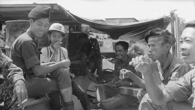 Jimmy comparte con un grupo de los soldados en un campamento. Algunos fuman cigarrillo, incluyendo a Jimmy.