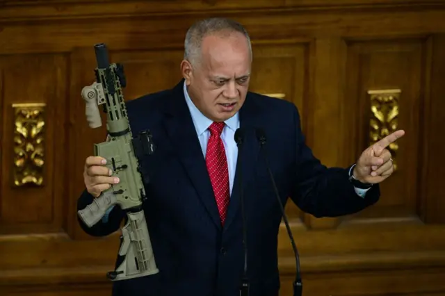 Cabello en un discurso en el Parlamento venezolano sostiene un rifle