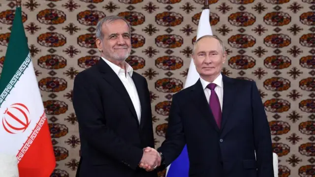 El presidente de Rusia, Vladimir Putin (d), le da la mano al presidente de Irán, Masoud Pezeshkian (i), en Ashgabat el 11 de octubre de 2024.