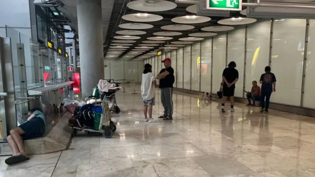 Personas en un pasillo del aeropuerto de Barajas.