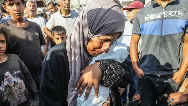 Una mujer llora mientras abraza los restos de Yahya al-Najjar, de 4 meses, quien murió de desnutrición severa en Khan Yunis, Gaza, el 20 de julio de 2025.