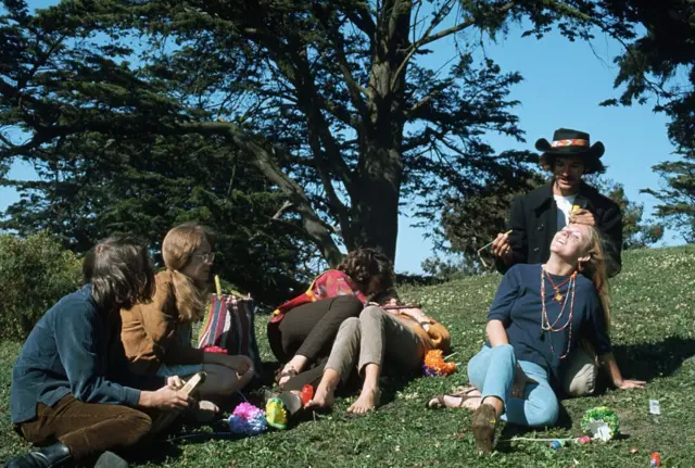 Un grupo de jóvenes sentandos en un parque.