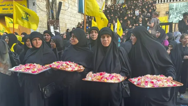 Mujeres con bandejas de pétalos