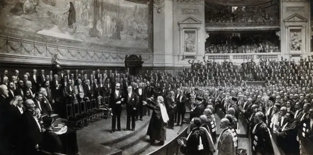 Lister (subiendo los escalones) se apresta a saludar al gran químico en las celebraciones por el 70º cumpleaños de Pasteur en la Sorbona, París, en 1892.