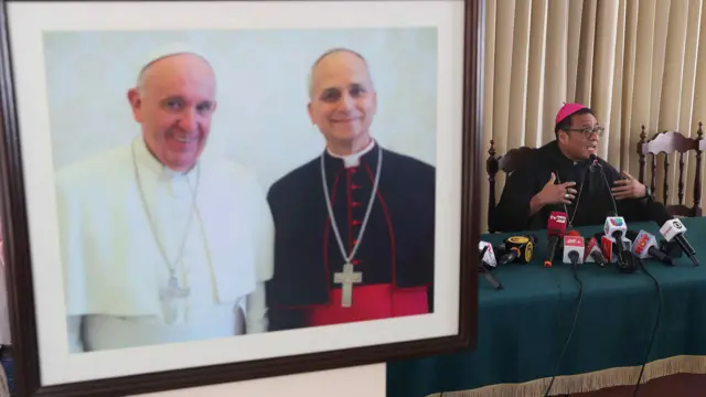 El obispo de Chiclayo, monseñor Edinson Farfán Córdova, habla durante una conferencia de prensa en Chiclayo, Perú, el 9 de mayo de 2025, junto a una fotografía del entonces obispo Robert Francis Prevost (R) junto al papa Francisco en el obispado de Chiclayo.