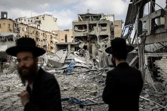 Unos ultraortodoxos judíos cerca de un barrio bombardeado por Irán