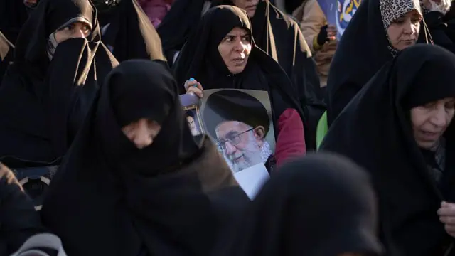Mujeres con velos negros sostienen una imagen del líder supremo de Irán, el ayatolá Ali Jamenei