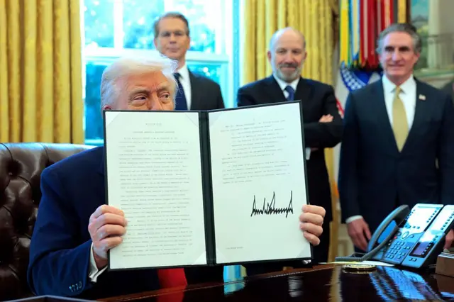 Trump muestra un decreto que firmó en la Casa Blanca