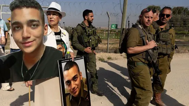 Varda Ben Baruch sostiene fotos de su nieto, el rehén israelí-estadounidense Edan Alexander, mientras camina cerca de soldados israelíes durante una concentración de familiares de rehenes retenidos en la Franja de Gaza, en Nir Oz, cerca de la frontera con la Franja de Gaza, el 20 de abril de 2025 en Nir Oz, Israel.
