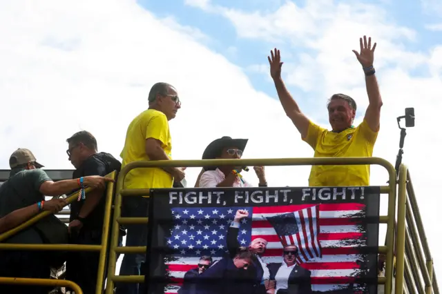 Jair Bolsonaro en una manifestación con una imagen de Trump sosteniendo una bandera de EE.UU.