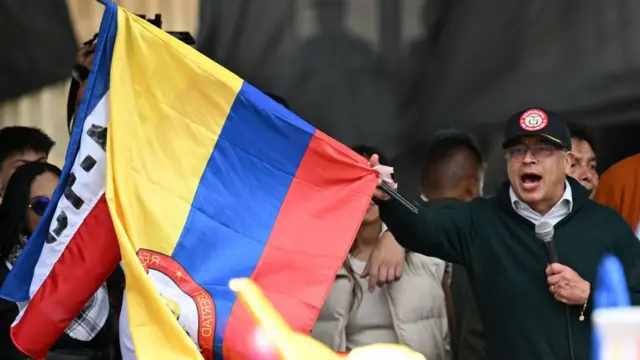 El presidente colombiano Gustavo Petro ondea una bandera nacional mientras pronuncia un discurso durante una manifestación por el Primero de Mayo (Día del Trabajo) en Bogotá el 1 de mayo de 2024.