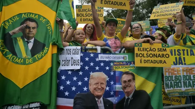 Partidarios del expresidente brasileño Jair Bolsonaro sostienen carteles alusivos durante una manifestación