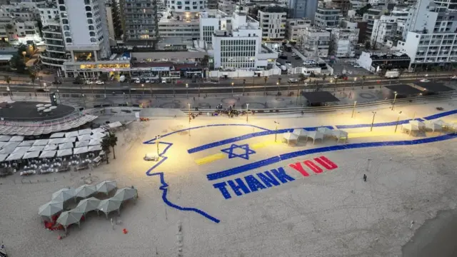 Un aviso gigante de agradecimiento, con el perfil del Trump y la bandera de Israel, desde una playa en Tel Aviv.