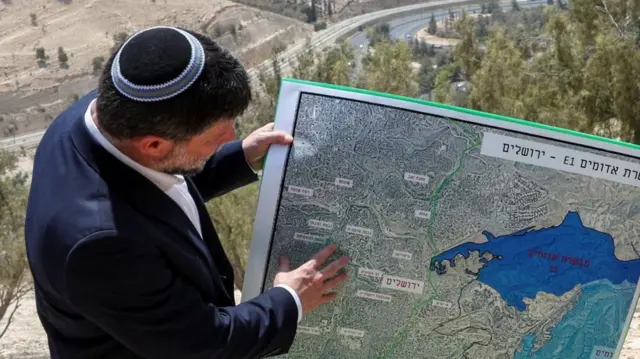 Smotrich, con chaqueta azul, observa un mapa que muestra el proyecto de asentamiento E1