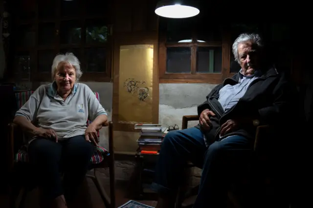 Lucía Topolansky y José Mujica sentados dentro de su casa