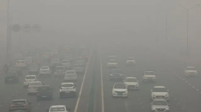 Vehículos en una autopista en Delhi en medio de una nube gris de contaminación