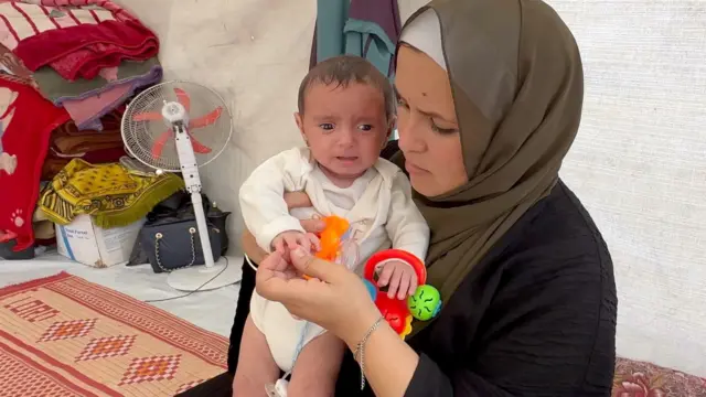 Niveen con su hija en brazos