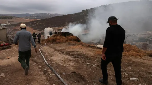 Palestinos apagan un incendio tras un ataque de colonos israelíes en  al-Ladain, cerca de la aldea de Beit Lid, en Cisjordiania