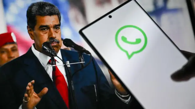 Un teléfono en el que se ve el logo de WhatsApp y detrás una foto del presidente  de Venezuela.