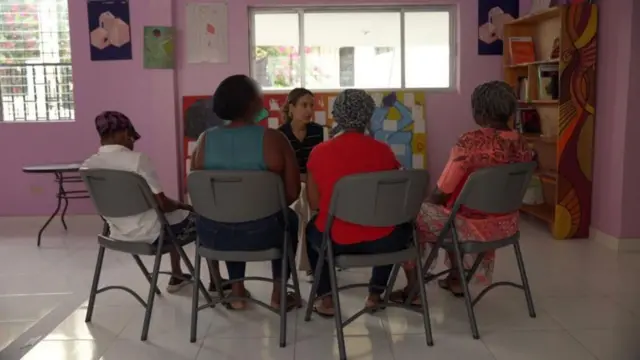 Periodista de la BBC escuchando el relato de cuatro mujeres sentadas de espaldas