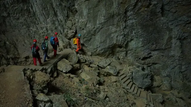 Los turistas descienden por la cueva