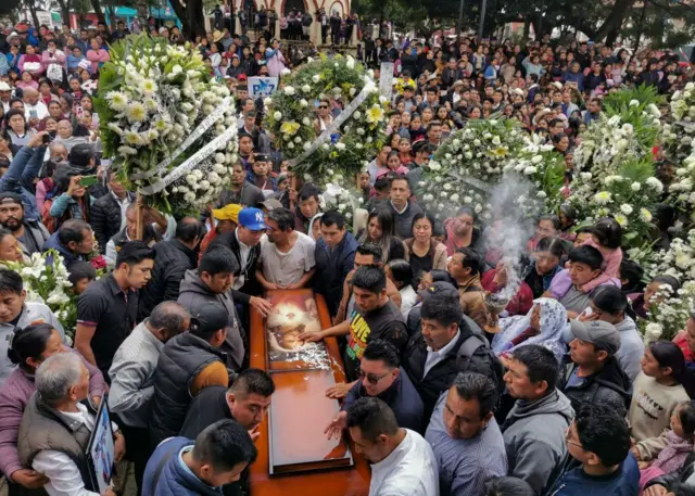 Gente aglomerada alrededor del ataúd de Marcelo Pérez durante su entierro. 