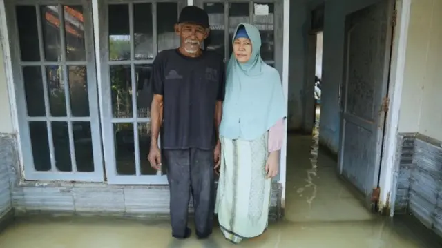 Suwandi y su esposa, Watini, en la terraza de su casa inundada en Blok Empang, Eretan Wetan, Indramayu.