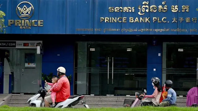 Automovilistas pasan frente a una sucursal del Prince Bank en Phnom Penh el 15 de octubre de 2025.